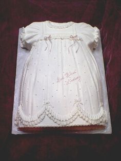 a cake shaped like a baby's christ gown