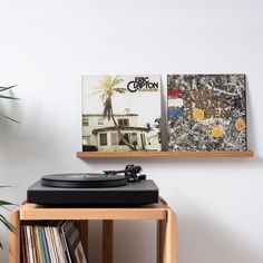 a record player sitting on top of a wooden table next to a wall mounted cd player