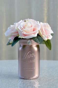 a pink rose in a mason jar on a table