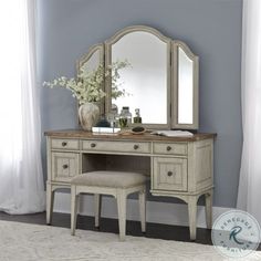 an antique vanity with mirror and stool in a room