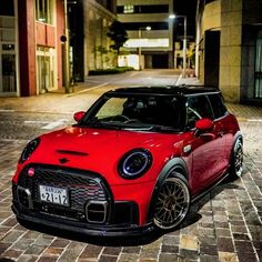 a small red car parked in front of a building