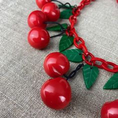 A fabulous big red cherry pendant necklace by Paris designer Marion Godart, crafted in red and green resin.  It features featuring 12 glossy red cherries and green leaves on a chunky red chain with hook and link fastening.  Adjust the necklace to the length you like : maximum length 22 inches / 56 inches  Each cherry is about 1 inch / 2.5cm diameter. Weight 125g.  Marion Godart is a well known Parisian designer who has been creating high quality statement jewellery since the 1980s. Her jewellery is sought after by couture houses and collectors alike, with a different range each year.  Perfect condition. SHIPPING Small, flat items are sent by lettre suivie / tracked letter. 🇫🇷For deliveries in France and Belgium, I normally use a relay service (Mondial Relay etc) to keep delivery costs lo Necklaces Cherry, Novelty Red Jewelry With Charms, Gold Cherry Necklace, Cherry Pendant, Cherry Necklace, Artisan Multi-strand Red Necklaces, Paris Design, French Design, Statement Jewelry