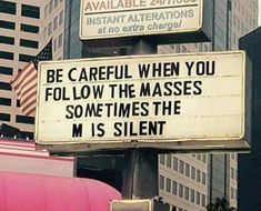 a sign that says be careful when you follow the masses sometimes the m is silent