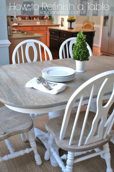 a table with white chairs and plates on it