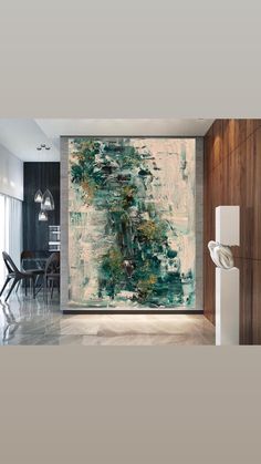 an abstract painting on the wall in a modern living room with white and green accents