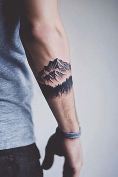 a man with a mountain tattoo on his arm