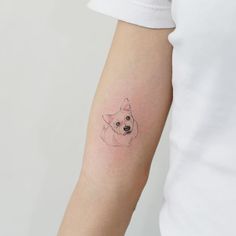 a small dog tattoo on the left arm