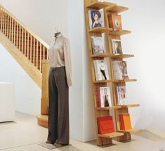 a mannequin is standing next to a bookcase