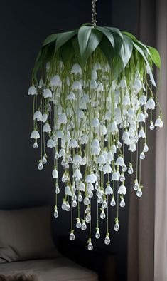 a white flower hanging from a ceiling in a living room with a couch and window