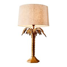 a lamp that has a palm tree on it with a light shade over the base