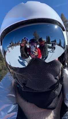 the reflection of three people in ski goggles