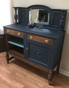 a blue painted dresser with two mirrors on it's sides and one drawer open