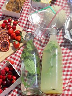 a table topped with lots of different types of food and drinks on top of a checkered table cloth