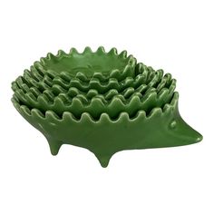 green ceramic hedgehog bowls stacked on top of each other in front of a white background