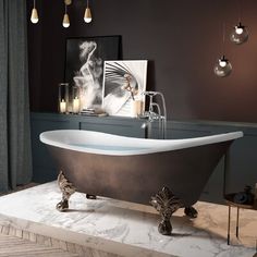 a bath tub sitting on top of a marble floor next to a painting and candles