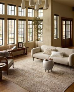 a living room filled with furniture and lots of windows