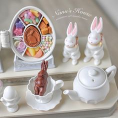 some bunny figurines sitting on top of a tray with candy and candies