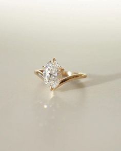 a yellow gold engagement ring with a single diamond in the center on a white surface