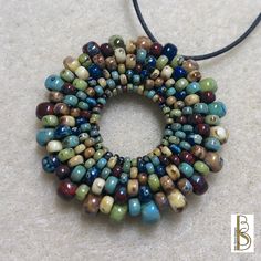 a beaded necklace with multicolored beads is displayed on a white carpeting surface