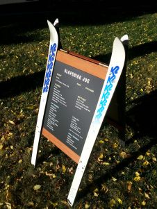 a sign with some skis on it in the grass