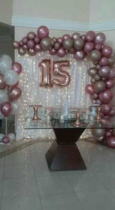 a large balloon arch with the number fifteen on it in front of a dining room table