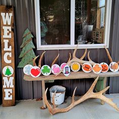 a wooden bench sitting next to a window with antlers on it's sides