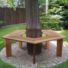 a wooden table sitting under a tree in the grass