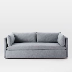 a gray couch sitting on top of a white floor