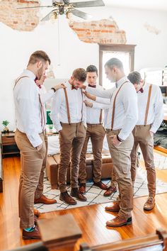 a group of young men standing next to each other in front of a mirror on top of a wooden floor