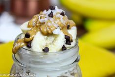 a banana split in a jar with chocolate chips and caramel on top, surrounded by bananas