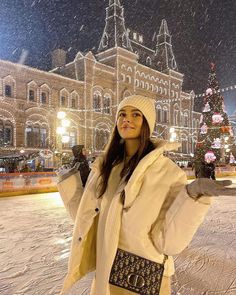 a woman standing in front of a christmas tree