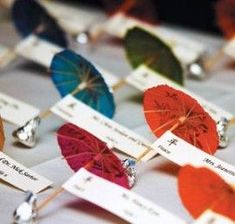 several colorful umbrellas with name tags attached to them sitting on top of a table