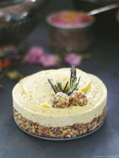 there is a small cake with lemon and rosemary on top, sitting on a table