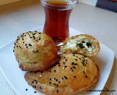 two pastries on a plate next to a cup of tea