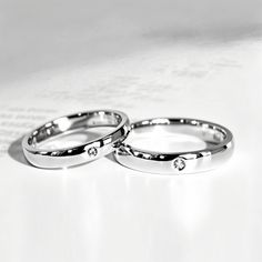 two wedding rings sitting on top of each other