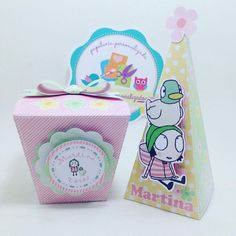 a pink box with a sticker on it next to a small gift bag