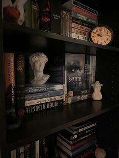 a book shelf filled with books and a clock on top of it next to other books