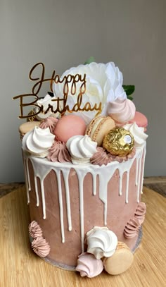 a birthday cake with pink icing and white flowers on the top that says happy birthday