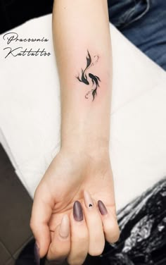 a woman's hand with a small tattoo on the wrist and an inked bird