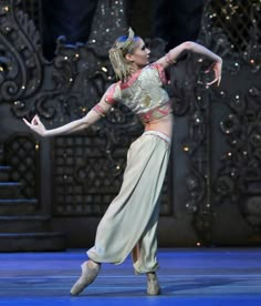 a woman is dancing on stage in a costume