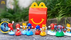 a group of toy figurines sitting next to a mcdonald's bag on the ground