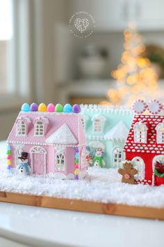 a close up of a small toy house on a table with a christmas tree in the background