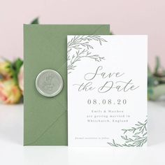 a wedding save the date card with a wax stamp on it and a green envelope