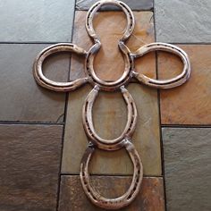 a cross made out of horseshoes on a tile floor