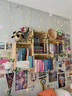 a bookshelf filled with lots of books next to a wall covered in pictures