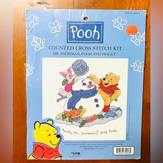 a winnie the pooh cross stitch kit on a wooden surface with an image of pooh and pooh