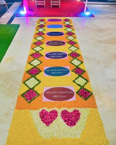 an aisle decorated with flowers and hearts on the floor in front of a red building