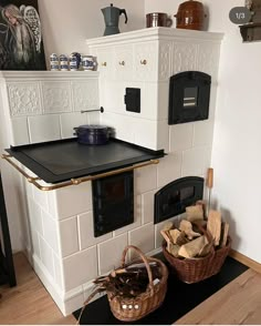 a stove top oven sitting inside of a kitchen next to a pile of firewood