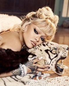 a woman laying on top of a white tiger