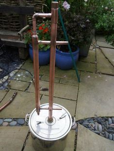 two metal pipes are attached to the top of a potted planter on a patio